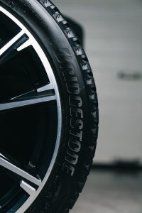 Detailed close-up of a Bridgestone tire mounted on a vehicle, showcasing tread and branding.